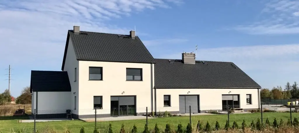 Dom z antracytowymi oknami i roletami zewnętrznymi